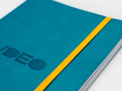 Close-up of a turquoise A5 diary with yellow elastic band