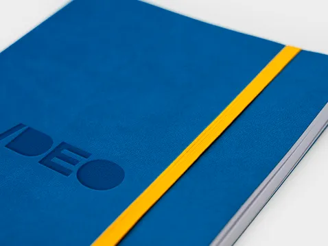 Close-up of a blue A5 diary soft cover with logo and yellow elastic band