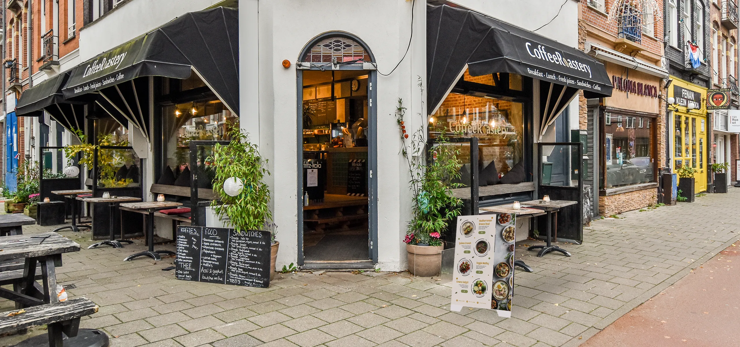 Double-sided PVC advertising A-board with menu placed in front of a café