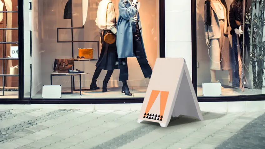 Double-sided PVC advertising A-board with print placed in front of a shop window