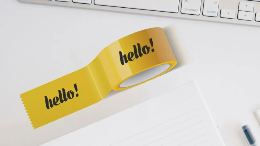 Yellow self-adhesive tape with print on a desk